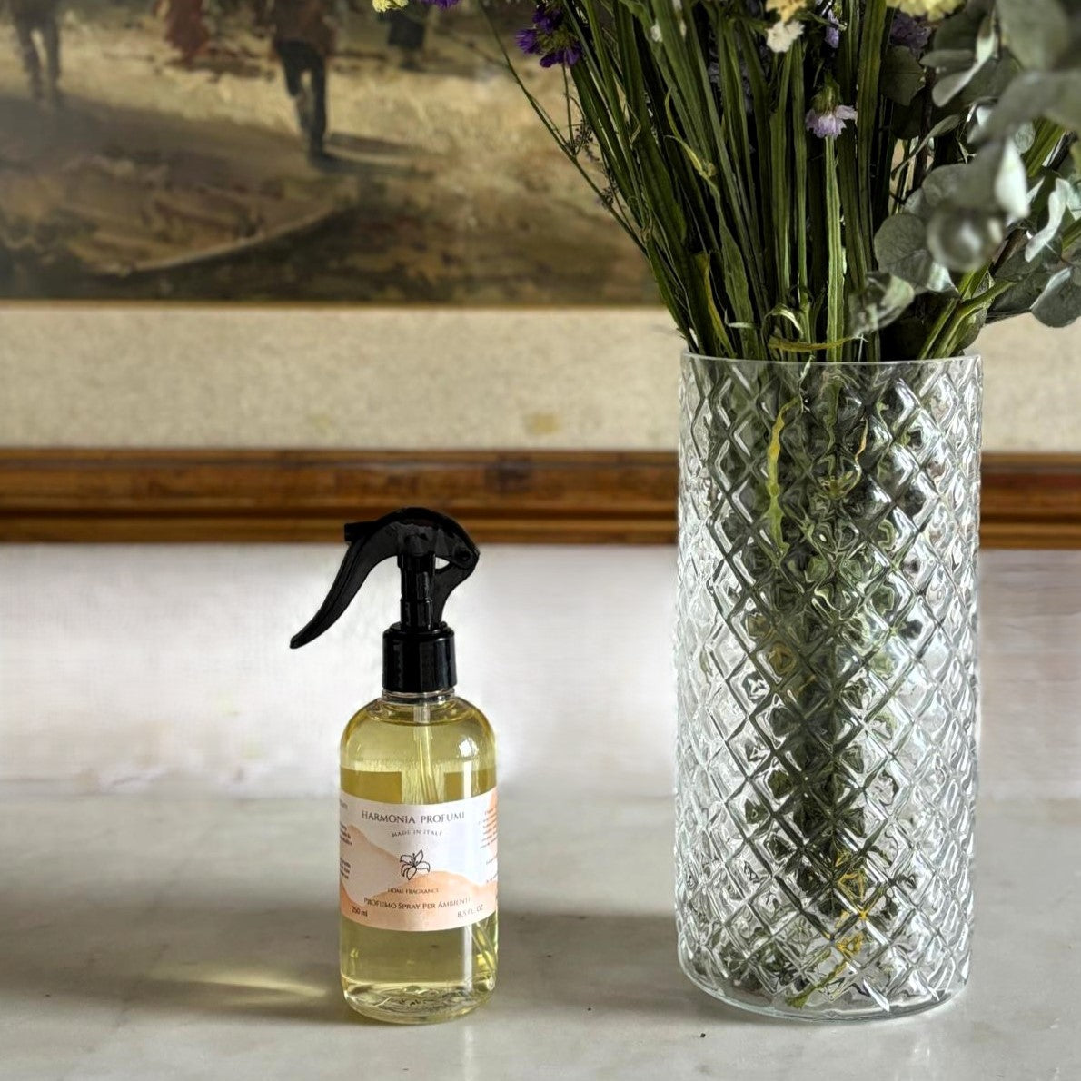 Fiori con un flacone di spray ambiente di Harmonia Profumi